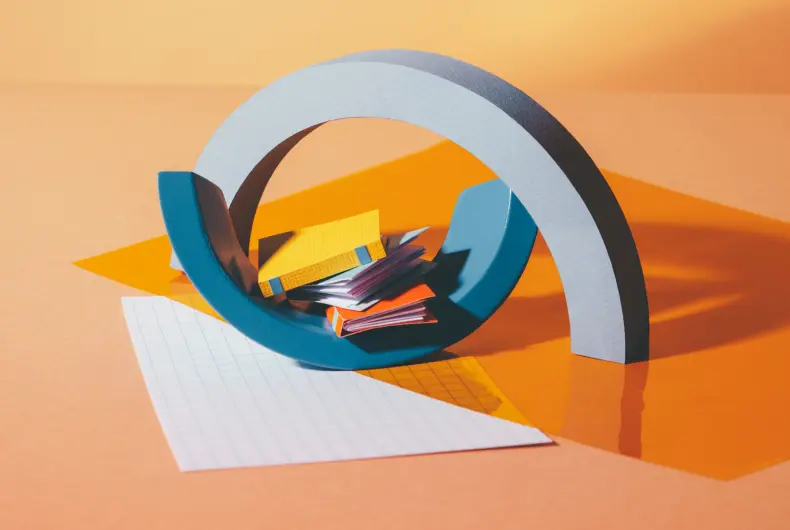 Vibrant orange background with a half-circle design prominently featuring an assortment of books and scattered pieces of paper, creating a dynamic and engaging composition